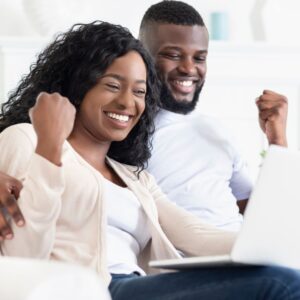 excited couple on laptop